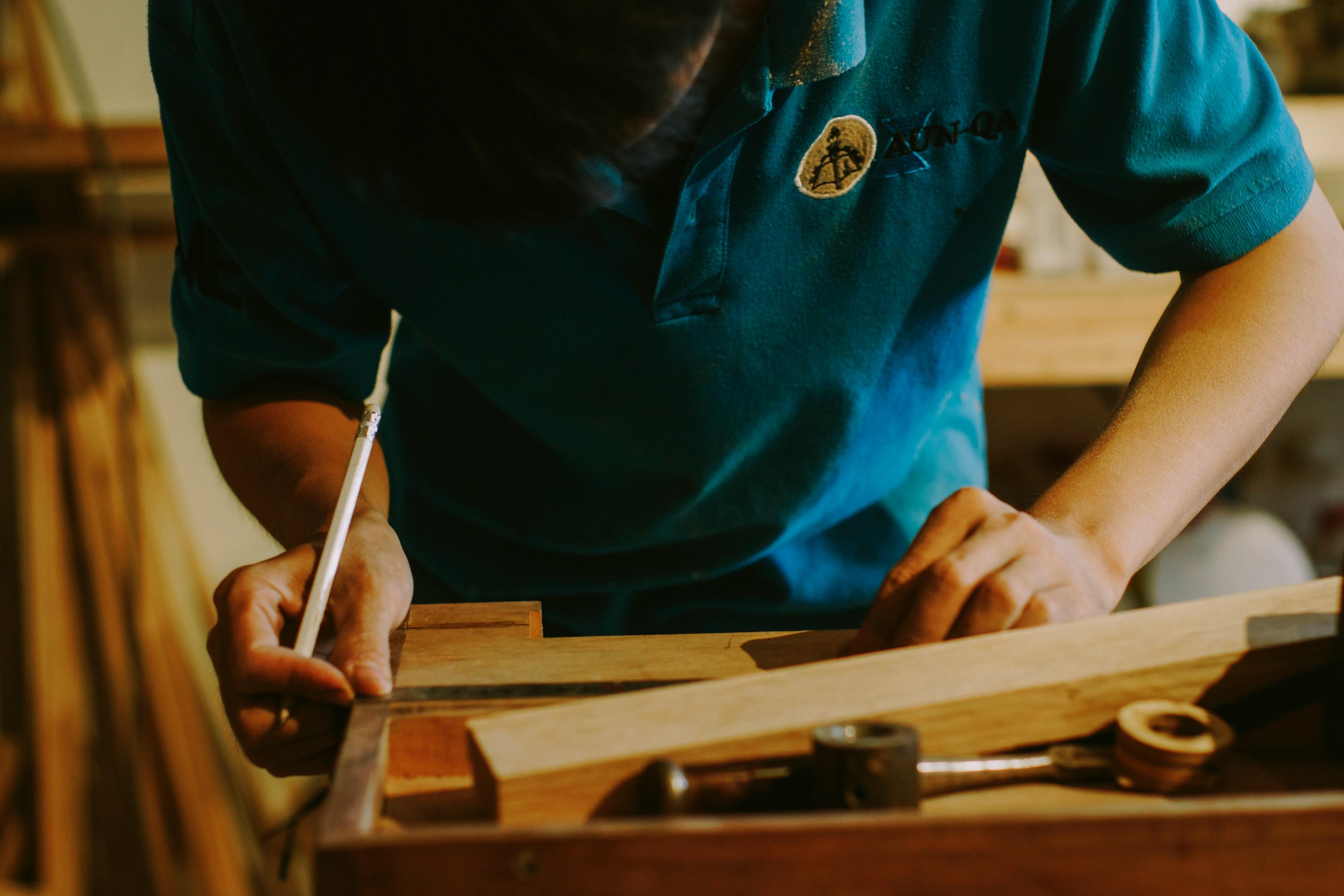 Apprentice Carpenter Measuring Lumber for a Woodworking project